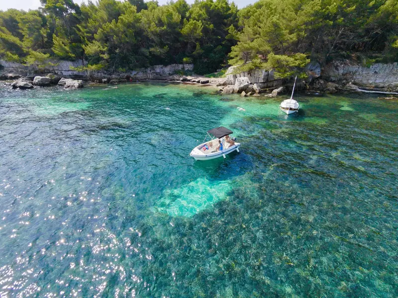 Location bateau Cannes : bateau au mouillage dans l'eau turquoise d'une crique des Îles de Lérins, vue aérienne